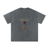 Front print of Masked Silence tee showing skeleton hand holding red rose beneath a silent quote on washed black cotton Pirate Gray